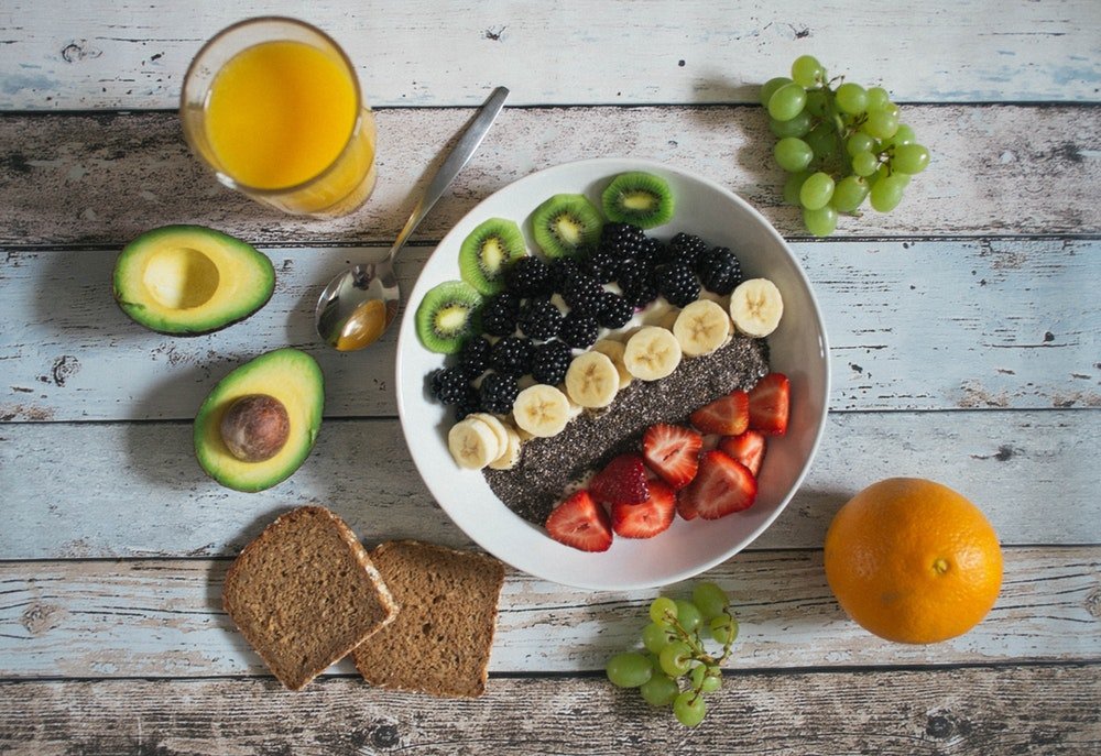 Trendy smoothie bowl with fresh fruit, avocado, chia seeds, and berries